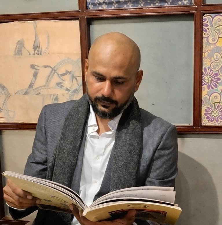 The artist in his studio, looking through a sketchbook.